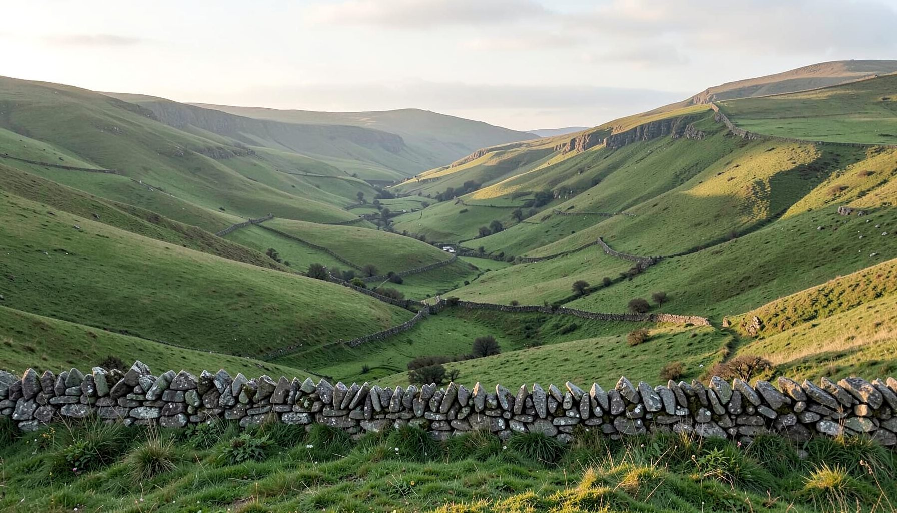 A serene Peak District landscape with rolling green hills, drystone walls, and soft morning light across the valley